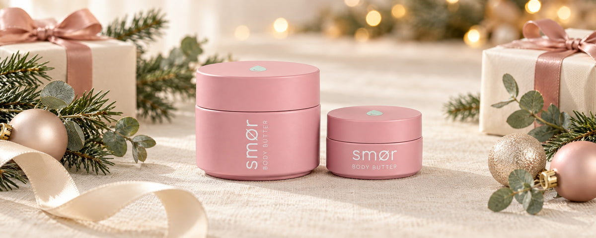 smør body butter jar and mini on a cream linen table with fir sprigs, eucalyptus and wrapped gifts